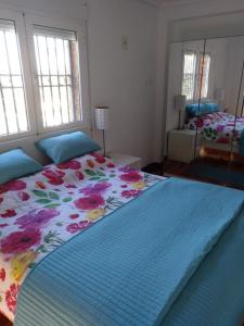 モンセラートにあるCasa assutzenaのベッドルーム1室(花柄のベッドカバー付きの大型ベッド1台付)