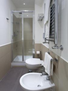 a bathroom with a toilet and a sink and a shower at Regola Suite in Rome