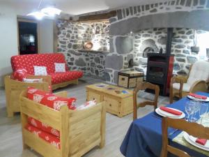 ein Wohnzimmer mit Holzmöbeln und einer Steinmauer in der Unterkunft Gîte de Bel Air in Anglards-de-Salers