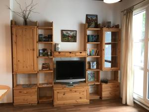a living room with a television on a wooden entertainment center at Holiday @ Bad Hindelang in Bad Hindelang