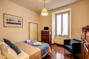 
a bedroom with a bed, chair, desk and a lamp at Boschetto in Rome
