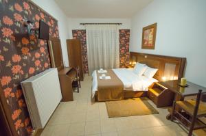 a hotel room with a bed and a desk at Rodavgi in Kato Loutraki