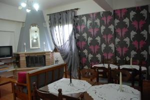 a dining room with two tables and a window at Guesthouse Rodavgi in Kato Loutraki