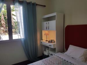 a bedroom with a bed and a window with a lamp at Villa Cosy Nook in Funchal