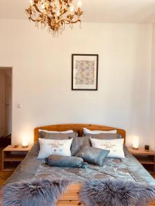 a bedroom with a bed with pillows and a chandelier at Golden GaPa Central Family Apartment 27 in Garmisch-Partenkirchen