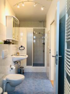 a bathroom with a toilet and a sink and a shower at Golden GaPa Central Family Apartment 27 in Garmisch-Partenkirchen