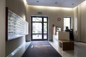 a lobby with a person sitting at a desk at P&O Serviced Apartments FABRYCZNA in Warsaw