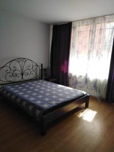 1 dormitorio con 1 cama y una ventana con cortinas en Orchid Apartment, en Gabrovo