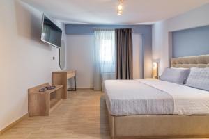 a bedroom with a bed and a flat screen tv at Oasis in Sarti