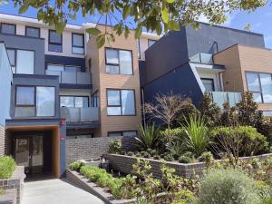 an image of a building with plants in front of it at Pride Bentleigh Apartment with Private Garden in Melbourne