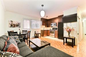 uma sala de estar com um sofá, uma mesa e uma cozinha em APARTMENT HOTEL ST-DENIS em Montréal
