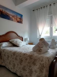 1 dormitorio con 1 cama con toallas en Apartamentos casa enrique, en Lires