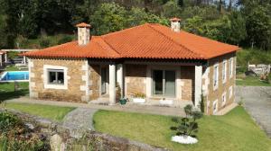 una pequeña casa de ladrillo con techo naranja en Charme da montanha, en Montaria