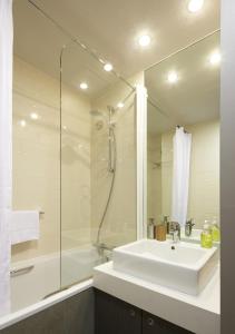 a white bathroom with a sink and a shower at Citadines Trafalgar Square London in London +9 photos