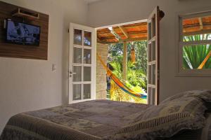 a bedroom with a bed and a sliding glass door at Pousada Estaleiro Village - Frente Mar in Balneário Camboriú