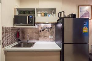 a kitchen with a sink and a refrigerator at Bangtao,Layan beach apartment in Bang Tao Beach
