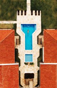 eine Luftansicht einer Person in einem Pool auf einem Gebäude in der Unterkunft Manga Verde Beach Residence in Itamaracá