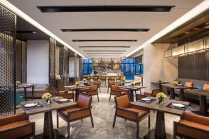 a restaurant with tables and chairs in a room at Somerset Harmony City Wuxi in Wuxi