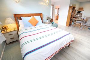 1 dormitorio con 1 cama grande con almohada naranja en Sea Salt Bnb, en Rosebud
