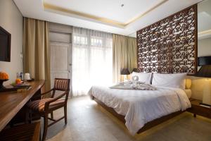 a hotel room with a bed and a desk and a desk at Segara Village Hotel in Sanur