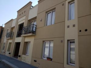 a building with windows and balconies on a street at Valle de Uco Departamentos Urbanos - Ruta 40 in Tunuyán