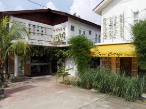 a white building with a yellow sign in front of it at The Serai Cottage Boutique Hotel in Kuala Berang