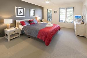 a bedroom with a large bed with a red blanket at Pelican Landing in Paynesville