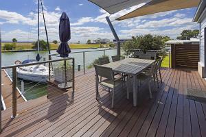 a wooden deck with a table and chairs on a boat at Pelican Landing in Paynesville