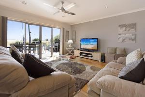 a living room with two couches and a flat screen tv at Pelican Landing in Paynesville