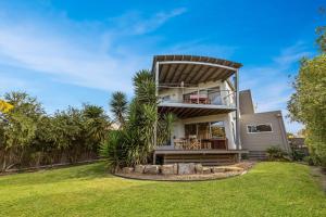 a house with a balcony on a lawn at Aqua Vista in Paynesville