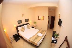a small room with a bed and a television at Fort Thari Inn in Galle