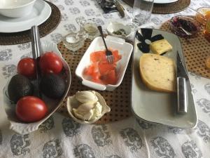 a table with a plate of food with tomatoes and cheese at The Inn At The Convent in Taumarunui