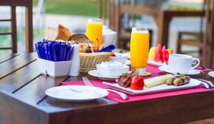 a table with breakfast foods and drinks on it at Amora Lagoon Hotel in Katunayaka