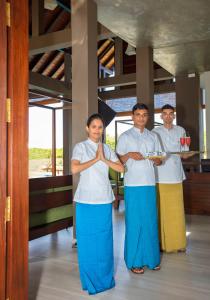 three women in suits standing in front of a kitchen at Amora Lagoon Hotel in Katunayaka