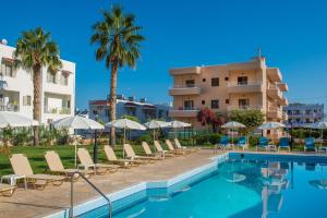 a hotel with a swimming pool with chairs and umbrellas at Niko Elen in Stalida