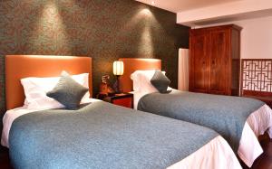 Postel nebo postele na pokoji v ubytování Jingshan Garden Hotel