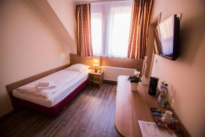 ein Hotelzimmer mit einem Bett und einem Tisch in der Unterkunft Hotel Heisede in Sarstedt