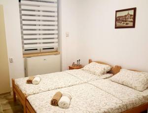 a bedroom with two beds with towels on them at Apartmani Maja Zrenjanin in Zrenjanin
