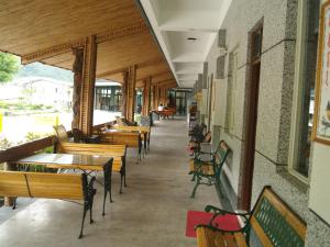 太麻里的住宿－金崙丹堤溫泉會館，餐厅里一排桌子和长椅