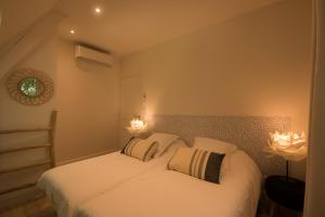 um quarto com duas camas e duas luzes na parede em Le Nid Douillet, climatisation et parking privé em Sarlat-la-Canéda
