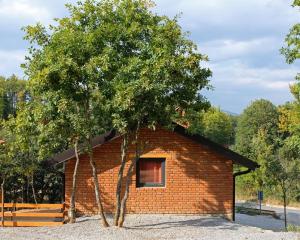 un pequeño edificio de ladrillo con un árbol delante de él en Lura Agroturizem, en Novoberdo