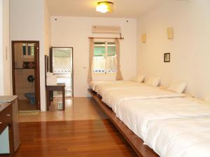 a bedroom with two beds and a desk in it at Dainty Spa Hotel in Taimali