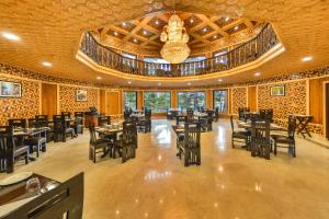 a dining room with tables and chairs and a chandelier at Royal Grandiose Pahalgam in Pahalgām