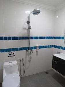 a bathroom with a shower and a toilet and a sink at Gm Motel in Kuah