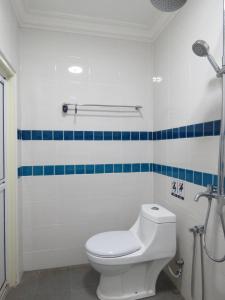 a bathroom with a toilet and blue and white tiles at Gm Motel in Kuah
