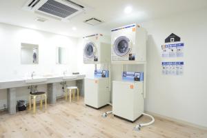 a laundry room with two washing machines and a sink at Otaru YaDo in Otaru