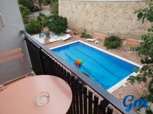 a swimming pool on a balcony with a table at Hostal Santa Gemma in Sant Vicenç de Montalt