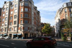 una macchina rossa parcheggiata di fronte a un edificio alto di Appt Hotel republique a Lille