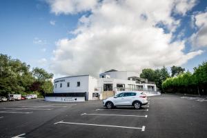 a car parked in a parking lot in front of a building at Waterfoot Hotel in Derry Londonderry