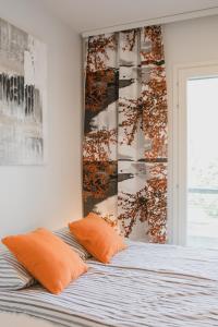 1 dormitorio con 1 cama con 2 almohadas de color naranja en First aparthotel Blitzen, en Rovaniemi